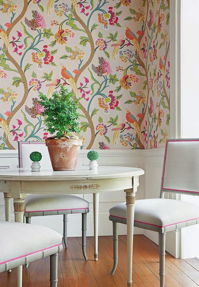 اتاق پذیرایی کلاسیک با صندلی و میز سفید رنگ که نیمی از دیوار آن دارای رنگ سفید و نیم دیگر آن دارای کاغذ دیواری گل و پرنده می باشد